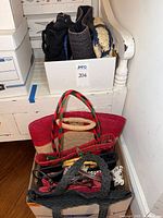 Boxes containing assorted tote handbags in various colors and weaves