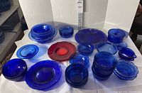 Overall view of assorted cobalt blue and red glass dishware laid out