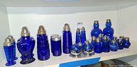 Full shelf view showing entire assortment of cobalt blue shakers and condiment jars