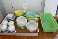 Tray view showing all glass items including jadeite loaf pan, pastel handled bowls, tulip bowls, blue cups and lidded jars