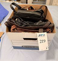 Box containing multiple leather handbags