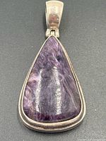 Front view showing teardrop charoite stone and silver bezel