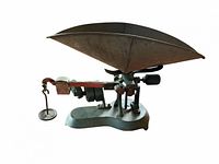 Right side view of antique beam balance scale showing pan, weights and hanging weight