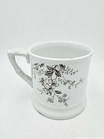 Front view of white ceramic scuttle mug with floral transfer