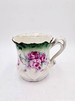 Front view of ceramic scuttle mug showing floral design and handle