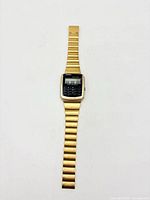 Full front view of gold Casio calculator watch with bracelet extended