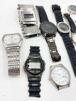 Group view of several watches including silver rectangular watch, black dial metal-band watch, Timex digital, white-dial watch head