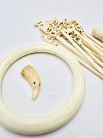 Bangle, claw pendant and group of skewers on white background