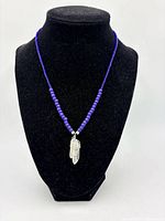 Full front view of necklace on black bust showing overall design and length