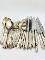 Knives, dinner forks and tablespoons displayed in rows