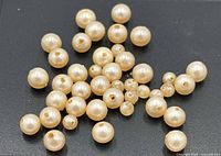 Loose round cream pearls spread on black background