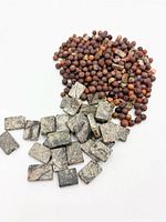 Pile of round brown gemstone beads and scattered rectangular grey marbled beads