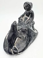Front left view of Inuit figure with seal carving