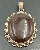 Front view of sterling silver pendant with brown cabochon