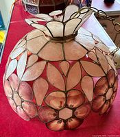 Large capiz shell lotus flower shade showing floral panels and brass chain