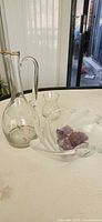 Pitcher, bud vase, bowl and amethyst stones grouped on surface