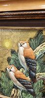 Front view showing framed oil painting with two birds perched on foliage