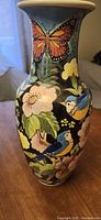 full view of vase front with bird, floral and butterfly motifs
