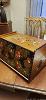 Angled view showing top, side and front floral painting and knob