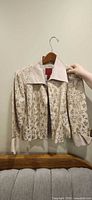 Front view of cream satin jacket showing beaded floral embroidery and overall style