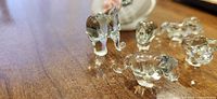 Group of clear glass elephant and other animals next to ceramic swan