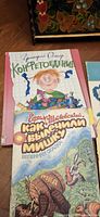 Group showing Grigoriy Oster hardcover, turquoise book, and spring tale paperback