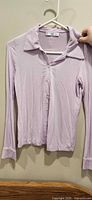 Front view of lilac button-up collared knit top on hanger
