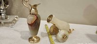 Ewer vase and wall sconce side by side with measuring tape for scale