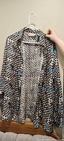 Front view of silk checkerboard button-up shirt on hanger