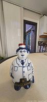 Front view of porcelain character liquor decanter with plaque and stopper