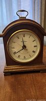 Front view showing dial, bezel, handle, wood case