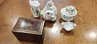 Group shot of wood box and five porcelain pieces on table