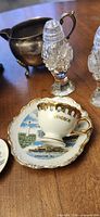 souvenir cup, saucer, crystal shakers, creamer visible