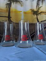 Front view of three 7UP upside-down glasses showing logo
