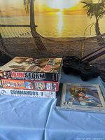 Front view of four PC game packages stacked beside wired controller