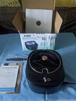 H80 ultrasonic UV cleaner with box, manual, tweezers and power cord displayed on table