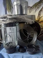 Lot overview showing stand mixer body, glass blender jar, processor bowl, whisk and attachments