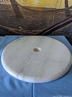 Top view of round marble base showing veining and center hole