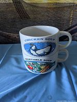Front view of both stacked mugs showing Chicken Soup and Vegetable Soup graphics