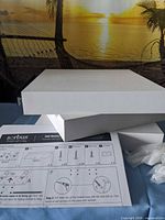 Three white shelves, instruction sheet, hardware bag visible