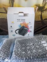 Retail box showing TCF 2300 telephone and bubble-wrapped contents
