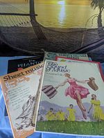 Front covers of four vintage musical theatre songbooks
