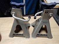 Front view of both ACDelco jack stands showing brand logo and saddle