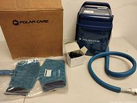 Full lot view showing Polar Care Cube unit, hose, therapy pad in plastic, power adapter in box, and original cardboard box
