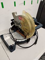 Front angled view showing Ryobi miter saw with blade guard and base