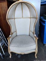 Front view of Safavieh hooded accent chair showing dome back, upholstery, wood frame
