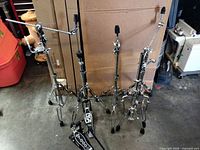 All five hardware pieces laid out: hi-hat stand, boom and straight cymbal stands, snare stand, DW 7000 pedal visible