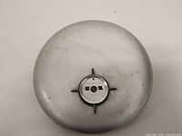 front view of round silver fire alarm bell