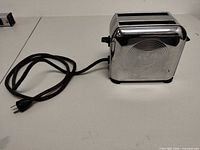 Left side view showing floral motif, cord, plug