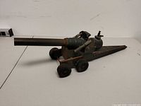 Left side view of entire cannon showing barrel, carriage, wheels